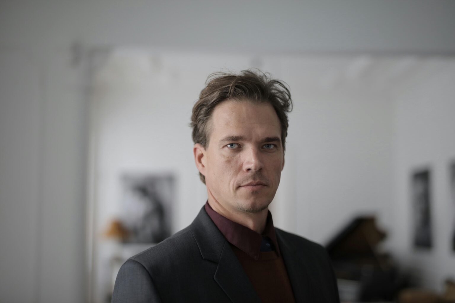 Leadership Confident businessman in a formal suit posing indoors with a serious expression.